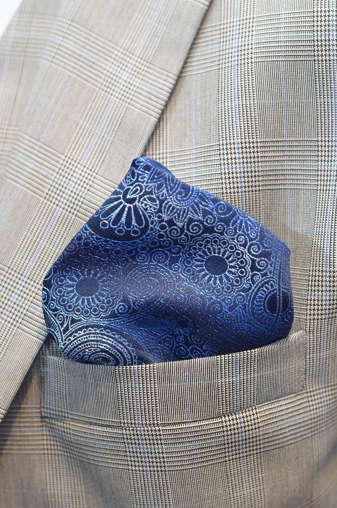 Blue paisley pocket square folded into a glen plaid jacket